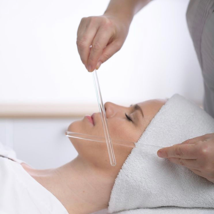 Person liegend bei einer Pflegebehandlung mit Glasstäben