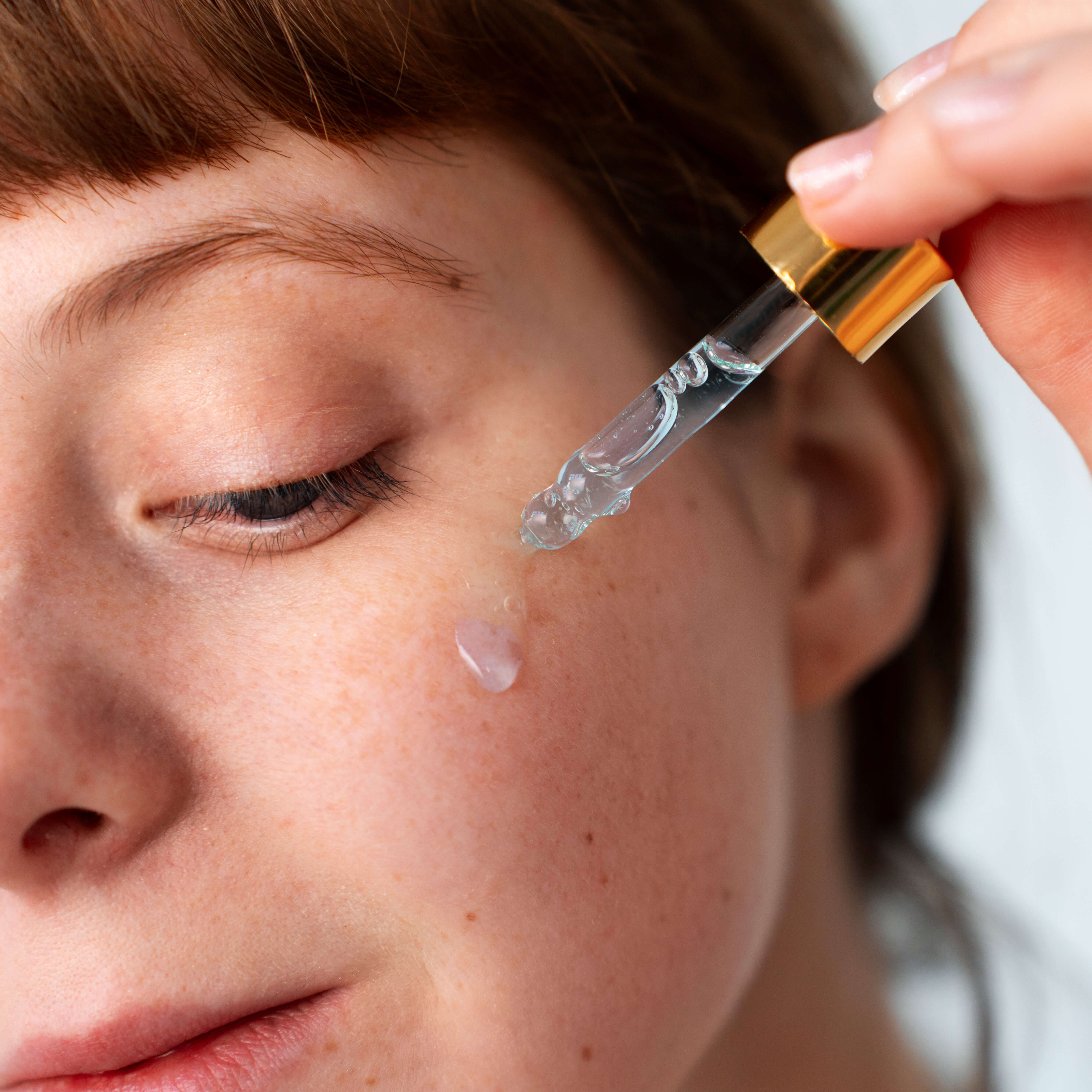 Frau mit Serum und Pipette im Gesicht